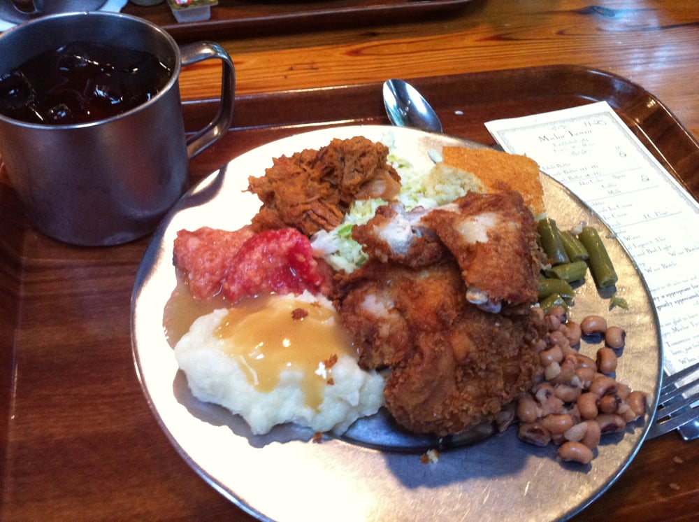 Plate of fried chicken, pulled pork, cole slaw, stewed tomatoes, green