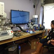 Rossmann Repair Group - New York, NY, United States. Someone fixes their own machine by soldering connector they ripped off at student station under microscope.