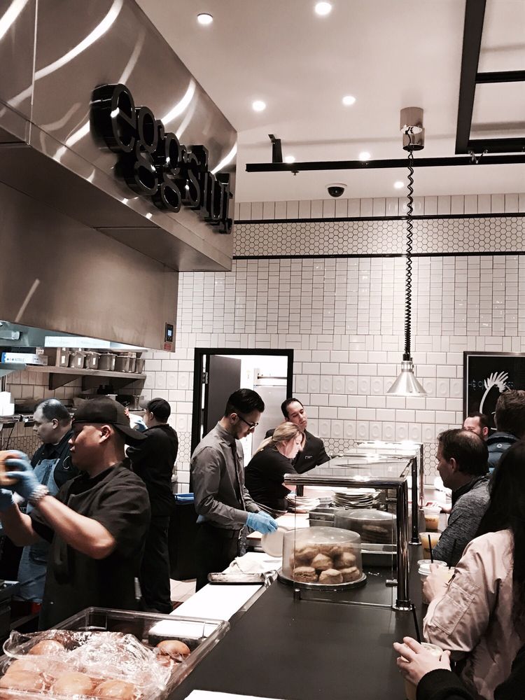Busy Kitchen busy kitchen, the manager (?) is putting napkins on plates while Busy Kitchen busy kitchen, the manager (?) is putting napkins on plates while